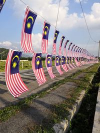 Multi colored flags on road against sky