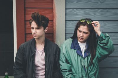 People looking away while standing against wall