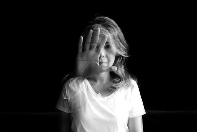 Portrait of woman against black background