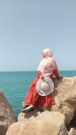 Low angle view of woman standing against sky