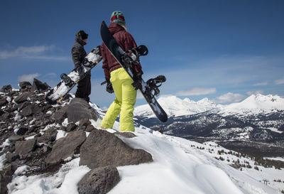 Low angle view of man and woman skiing on snowcapped mountain