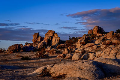Desert dawn with clouds over rocky landscape during golden hour