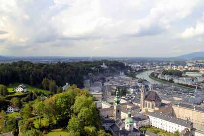  the view on the city and park with red and white flowers in the sunny day.