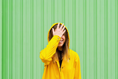 Young woman standing against curtain