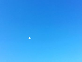 Low angle view of moon against clear blue sky