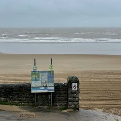 Lifeguard hut on beach against sky