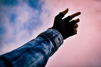 Midsection of man holding cigarette against sky
