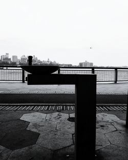 Bridge over river in city against clear sky