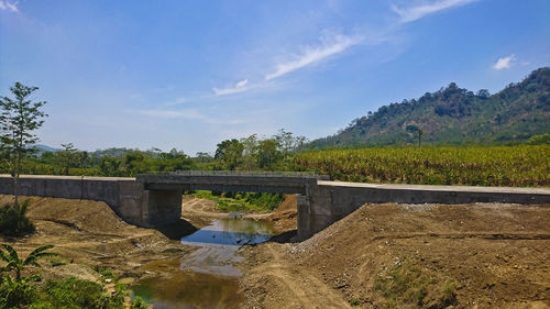 Arch bridge over river against sky