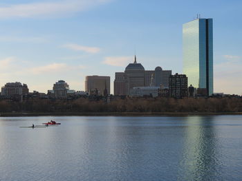 Scenic view of river by buildings against sky