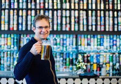 Portrait of a smiling young man drinking glass