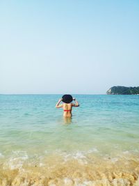 Rear view of woman in sea on sunny day
