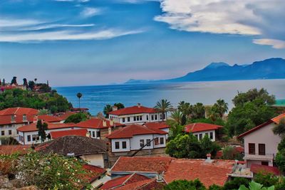 Houses by sea against sky