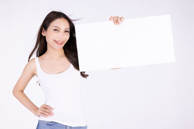Portrait of a smiling young woman against white background