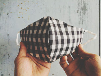 Midsection of person holding hands against wall