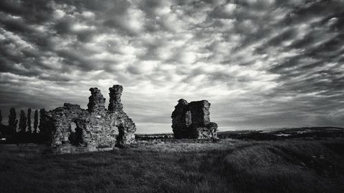 Old ruin on field against sky