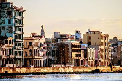 Buildings in city against cloudy sky