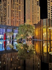 Reflection of buildings on glass window at night