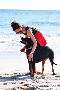 Young woman with a dog on the beach