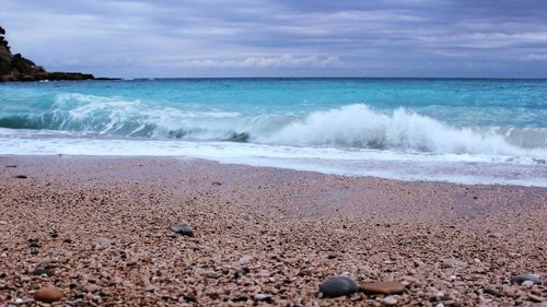 Scenic view of beach against cloudy sky