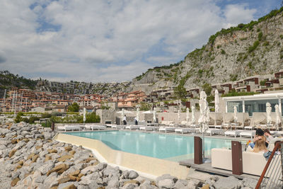 Swimming pool by mountain against sky