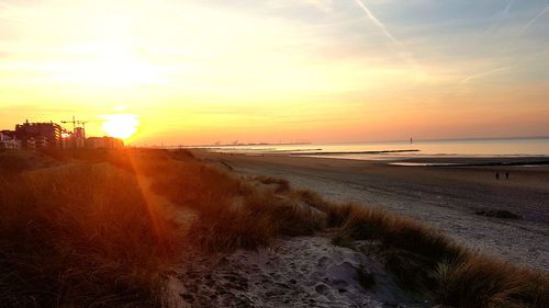 Scenic view of beach against sky during sunset