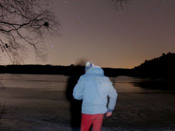 Rear view of woman walking on snow covered land