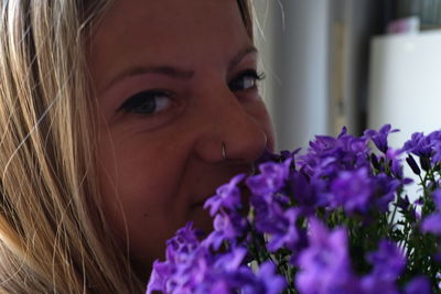 Close-up portrait of woman with purple flower