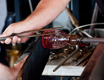 Cropped image of man making glass blower at factory