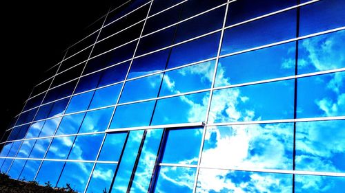 Low angle view of modern building against blue sky