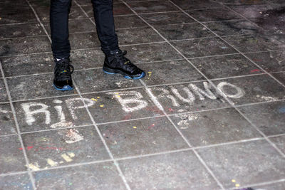 Low section of person standing on tiled floor