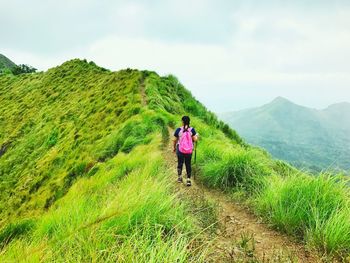 Rear view of woman on mountain against sky