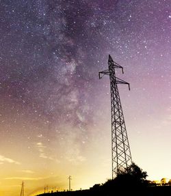 Low angle view of silhouette electricity pylon against sky at night