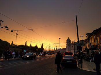 Cars on road in city at sunset