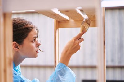 Young woman painting furniture