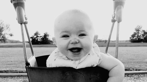 Portrait of cheerful cute baby girl on swing