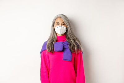 Portrait of woman standing against white background