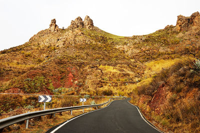 Empty road amidst mountains against clear sky at pilancones park