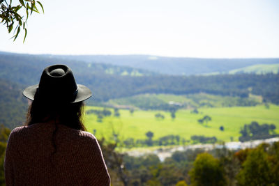 Rear view of woman looking at mountains against sky