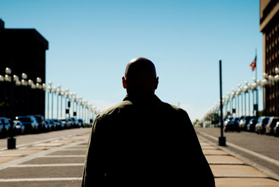 Rear view of man standing on bridge against sky