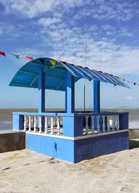 Built structure on beach against blue sky