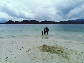 People on beach against sky