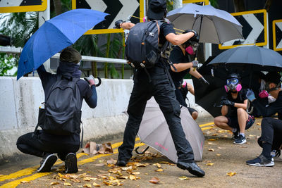 Rear view of people walking on wet street