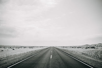 Empty road along countryside landscape