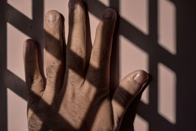 Close-up of human hand on wall