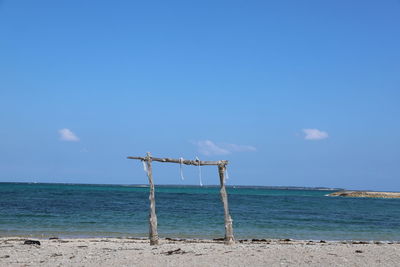 Windmill on beach against sky