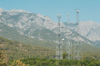 Electricity pylon on mountain against sky