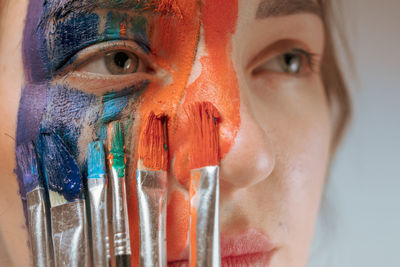 Close-up of young woman painting face
