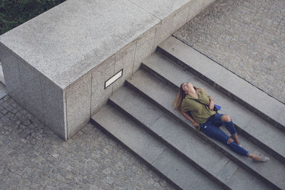 High angle view of woman relaxing on staircase
