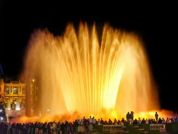 Crowd at music concert against sky at night